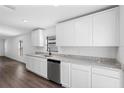 White shaker cabinets, granite countertops, and stainless steel dishwasher at 29603 Fedora Cir, Brooksville, FL 34602