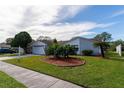 House exterior with a landscaped yard, two-car garage, and a welcoming front entrance at 4726 Windflower Cir, Tampa, FL 33624