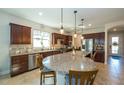 Open kitchen with stainless steel appliances, granite countertops, large island and stylish pendant lighting at 4748 Ballast Crest Cv, Land O Lakes, FL 34638