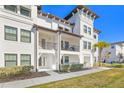 Two-story white building with balconies, brown roof, and landscaping at 5351 Bridge St # 67, Tampa, FL 33611