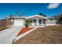 Charming single-story home with a well-maintained lawn and inviting front porch seating at 5405 Golden Nugget Dr, Holiday, FL 34690