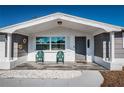 Inviting front porch seating area with white rock and tile at 5405 Golden Nugget Dr, Holiday, FL 34690