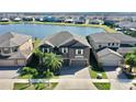 Two-story house on a lake with other homes visible in the background at 9919 Smarty Jones Dr, Ruskin, FL 33573