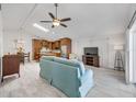 Open-concept living room with tile floors, ceiling fan, and skylight, blending seamlessly with the kitchen at 11045 Springridge Dr, Tampa, FL 33624