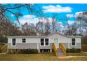 Modern manufactured home features gray siding, a white upper section, and a wooden staircase at 13017 Manatee Ave, New Port Richey, FL 34654