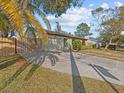 Exterior of charming single-story home with a fenced yard and long driveway at 1310 Meres Blvd, Tarpon Springs, FL 34689