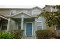 Two-story townhome with light blue exterior, a blue front door, and landscaping at 1552 Blue Magnolia Rd, Brandon, FL 33510