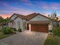 Stunning curb appeal with a brick driveway and American flag at 16959 Scuba Crest St, Wimauma, FL 33598