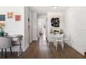 Bright dining area with white table and chairs, hardwood floors, and modern art at 2353 Shelley St # 15, Clearwater, FL 33765