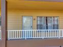 Condo entrance with a white railing and a brown door at 2402 Ecuadorian Way # 28, Clearwater, FL 33763
