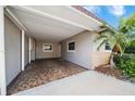 Covered carport with tiled flooring attached to the house at 272 Portree Dr, Dunedin, FL 34698