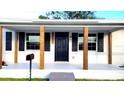 Inviting front porch with wooden posts and black front door at 2724 20Th S St, St Petersburg, FL 33712