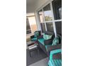 Comfortable outdoor seating with teal accents on screened in porch at 301 E Grace St, Punta Gorda, FL 33950
