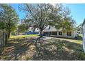 Large backyard with a large tree and screened porch at 3522 E 26Th Ave, Tampa, FL 33605