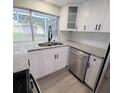 White shaker cabinets, granite counters, and stainless steel sink at 3546 Cheswick Dr, Holiday, FL 34691