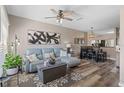 Living room with light teal sectional sofa, wood-look floors, and large windows at 388 Countryside Key Blvd, Oldsmar, FL 34677