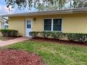 Front view of a yellow single story home with white door and landscaping at 401 Dorchester Pl # 62, Sun City Center, FL 33573