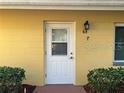 White front door of a yellow single story home at 401 Dorchester Pl # 62, Sun City Center, FL 33573
