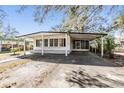 White single story home with carport and landscaped yard at 4711 Olive Dr, Zephyrhills, FL 33542