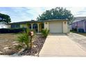 House exterior with a large driveway and lawn at 7614 Karen Dr, Port Richey, FL 34668