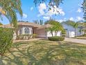 House exterior showcasing landscaping and a two-car garage at 805 Anchors Way, Tarpon Springs, FL 34689