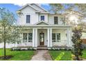 Inviting two-story home boasts a covered front porch with craftsman columns and landscaped lawn at 870 29Th N Ave, St Petersburg, FL 33704