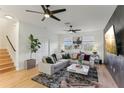 Living room featuring an L-shaped sofa, large windows, stylish decor, and neutral color palette at 10144 Arbor Run Dr # 107, Tampa, FL 33647