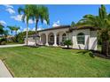 White house with palm trees, arched entryway, and spacious lawn at 1257 Kings Way Ln, Tarpon Springs, FL 34688