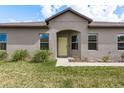 Inviting single-Gathering home displaying a well-kept lawn, a cozy entryway, and simple, yet appealing landscaping at 13387 Crest Lake Dr, Hudson, FL 34669