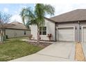 Attractive single-Gathering home boasting a two-car garage, complemented by a well-maintained lawn and vibrant front yard landscaping at 13387 Crest Lake Dr, Hudson, FL 34669