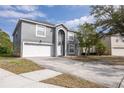 Two-story house with gray exterior, white garage door, and landscaping at 1703 Alhambra Crest Dr, Ruskin, FL 33570