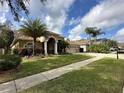 House with palm trees, a three car garage, and a red front door at 3011 Marble Crest Dr, Land O Lakes, FL 34638