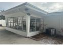 Sunroom addition with many windows, white exterior and A/C unit at 3553 Center Cir, Largo, FL 33774
