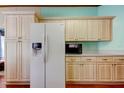 Bright kitchen featuring a new refrigerator and light wood cabinetry providing ample storage at 3841 Julie Dr, Wesley Chapel, FL 33543