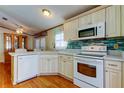 Bright kitchen with white appliances, natural wood cabinets, and a stylish backsplash at 3841 Julie Dr, Wesley Chapel, FL 33543