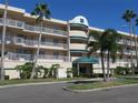 Exterior view of a condo building with palm trees and a green awning at 6315 Shoreline Dr # 3208, St Petersburg, FL 33708