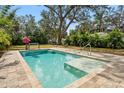 Relaxing rectangular pool with a tanning ledge and surrounding stone pavers at 1061 Sedeeva St, Clearwater, FL 33755