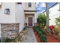 Inviting front entrance with brick accents and landscaping leading to a cozy, covered porch at 12408 Victarra Pl, New Port Richey, FL 34655