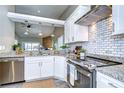 Modern kitchen features stainless steel appliances, granite countertops and white subway tile backsplash at 13908 Orange Dale Pl, Tampa, FL 33625