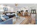 Open-concept living room featuring hardwood floors, ceiling fan, and a view of the kitchen at 15110 Shearcrest Dr, Lithia, FL 33547