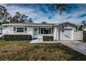 Charming single-story home featuring manicured bushes, an American flag, and a garage at 1570 S Michigan Ave, Clearwater, FL 33756