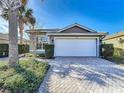 House exterior featuring a white garage door and brick driveway at 15856 Cobble Mill Dr, Wimauma, FL 33598