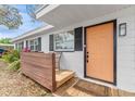 Inviting front porch with wood accents, a chair for relaxing, and a freshly painted orange front door at 1707 Darlington Dr, Tampa, FL 33619