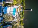 An aerial view of the community pool, dock, and lake creates an inviting scene for prospective residents at 1708 Sunset Wind Loop, Oldsmar, FL 34677