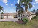 Elegant home showcasing a three-car garage, tile roof, and verdant lawn at 17336 Ballmont Park Dr, Odessa, FL 33556