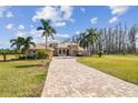 Inviting home exterior featuring a long driveway and well-manicured landscaping at 17336 Ballmont Park Dr, Odessa, FL 33556