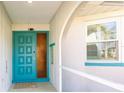 Front entrance with a teal door and glass sidelight, welcoming and bright at 18719 Van Nuys Cir, Port Charlotte, FL 33948