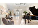 Spacious living room with a grand piano, comfortable seating, and large artwork at 3312 Cobbs Ct, Palm Harbor, FL 34684