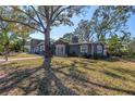 Beautiful home exterior featuring mature trees, a well-manicured lawn, and charming architectural details at 540 Villagrande S Ave, St Petersburg, FL 33707