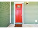 A vibrant red front door with glass detail and welcome mat at 5644 Missouri Ave, New Port Richey, FL 34652